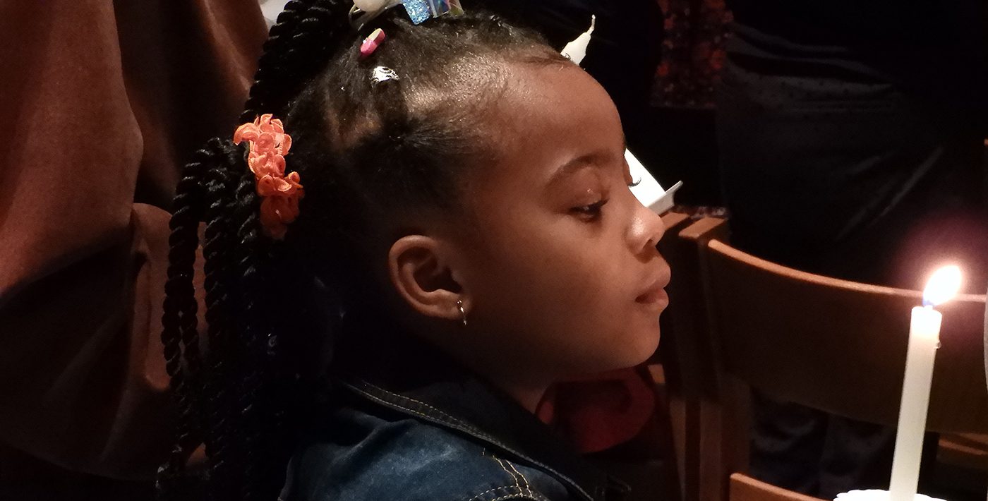 A child holding a candle at Trinity (photo from the parish's current website)